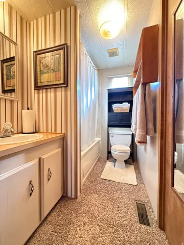 Full bathroom featuring vanity, a textured ceiling, and shower / tub combo
