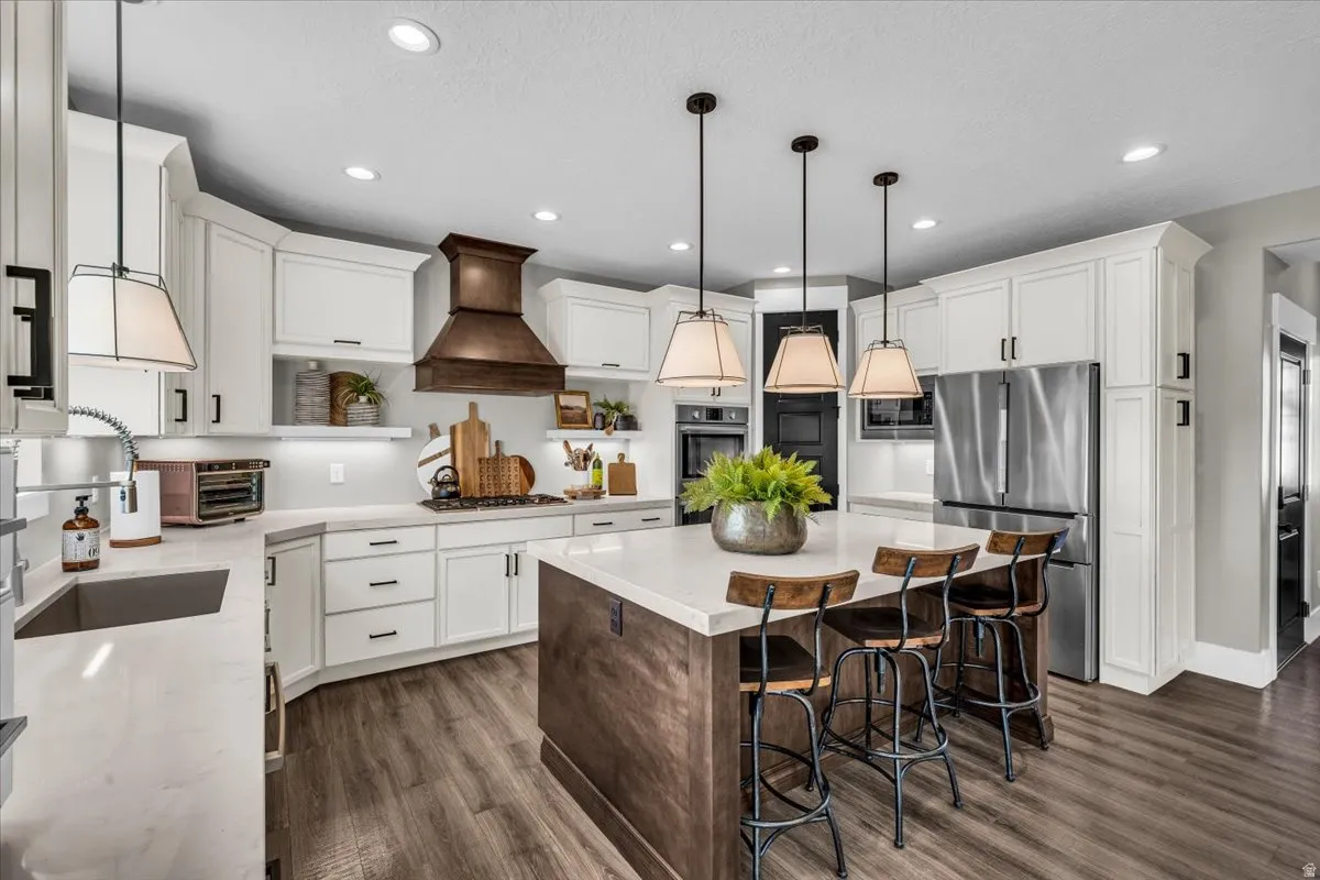 Kitchen featuring open shelves, a center island, a breakfast bar area, stainless steel appliances, and dark wood-type flooring