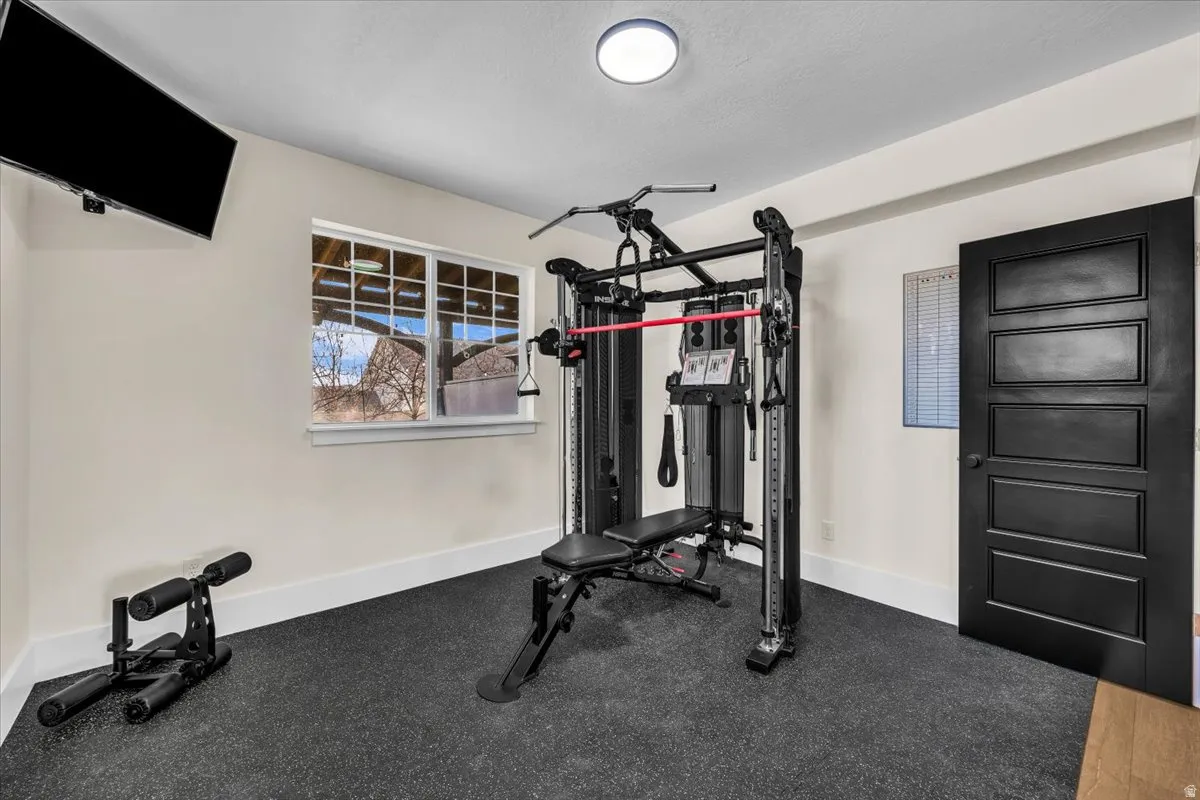 Workout room featuring baseboards and rubber floors