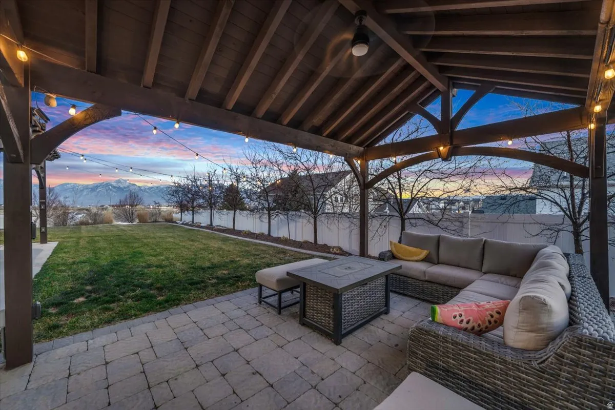 Fenced backyard featuring a patio area, outdoor seating, and a mountain view