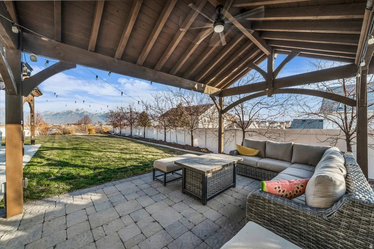 Fenced backyard featuring a patio area, outdoor lounge area, ceiling fan, and a mountain view