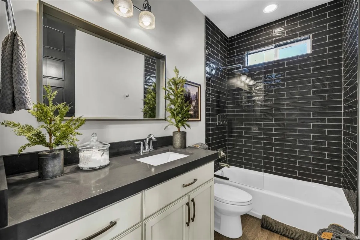 Full bathroom featuring vanity, bathtub / shower combination, and dark wood-type flooring