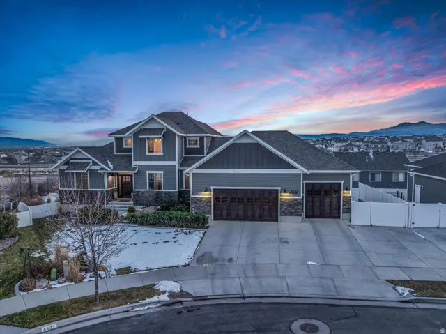 Craftsman-style house with a gate, stone siding, a garage, and board and batten siding