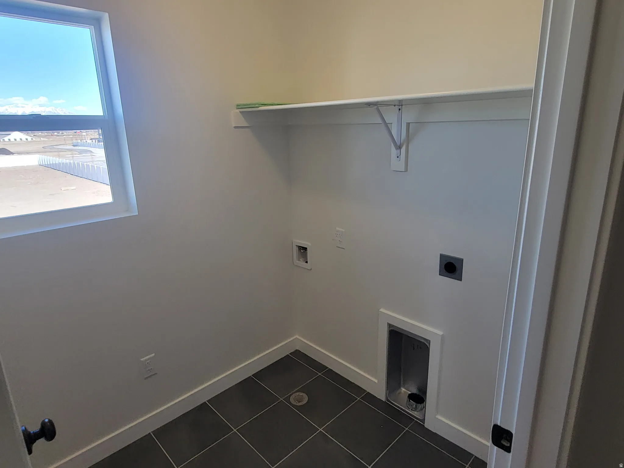 Laundry room featuring washer hookup, dark tile patterned flooring, and hookup for an electric dryer