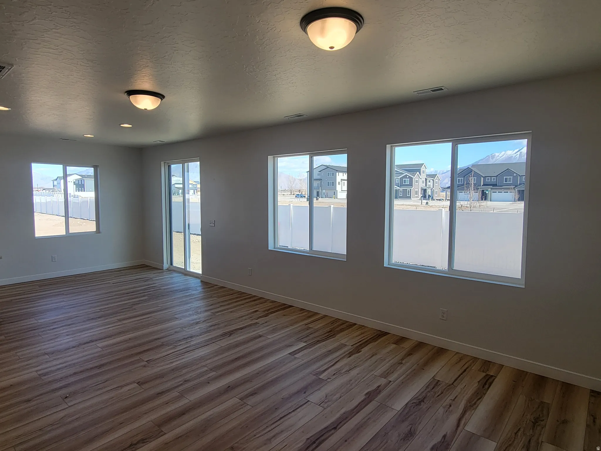 Spare room featuring a textured ceiling and light wood-style floors