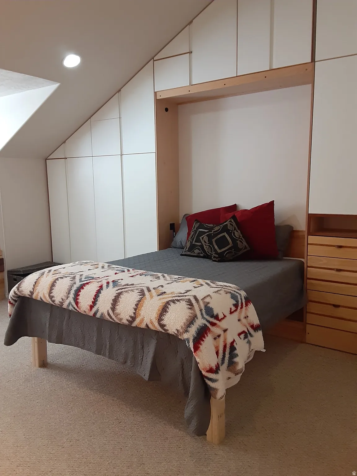 Bedroom featuring vaulted ceiling, murphy bed,  light colored carpet, and recessed lighting