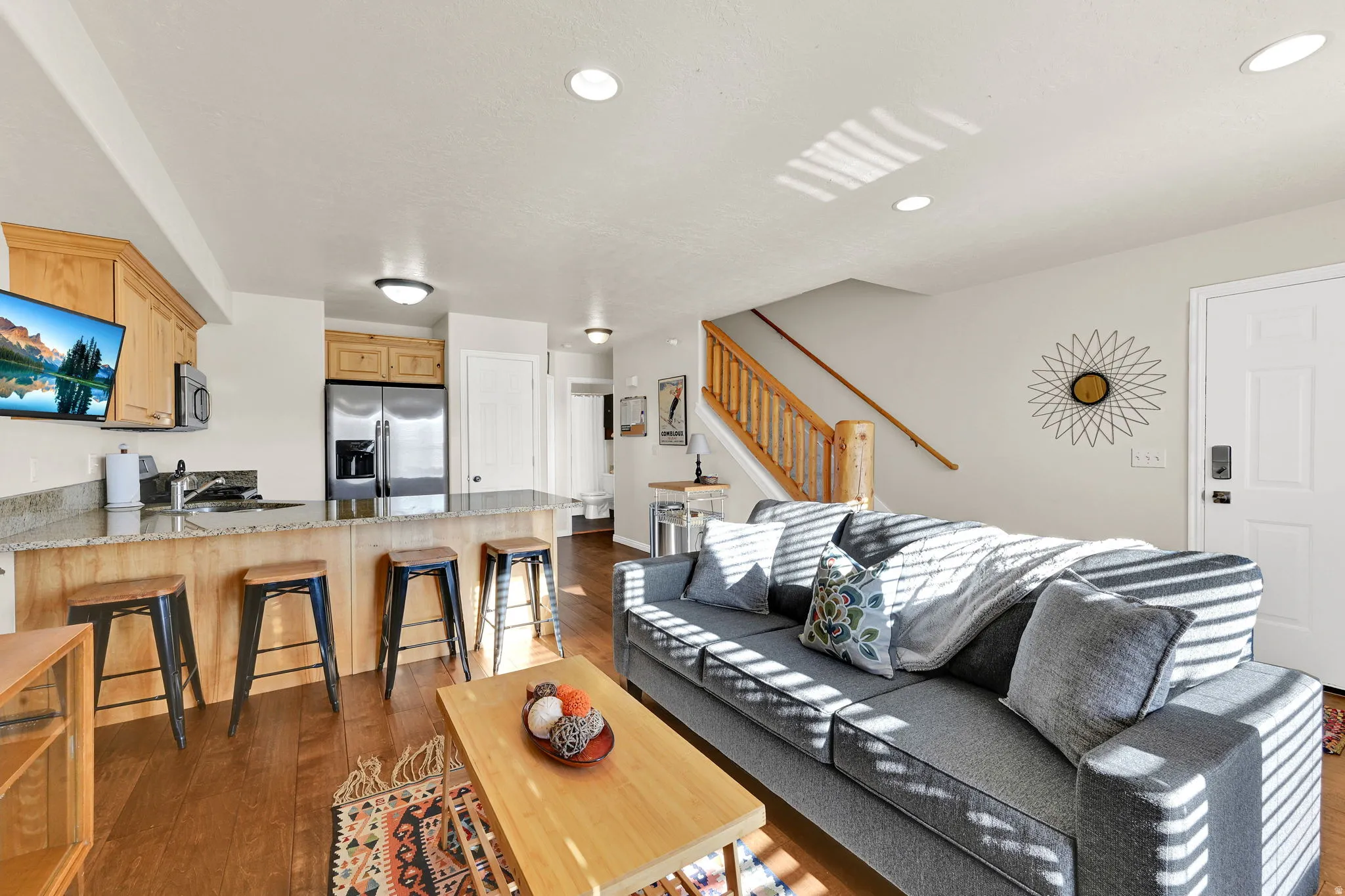 Living area with dark wood-type flooring and recessed lighting