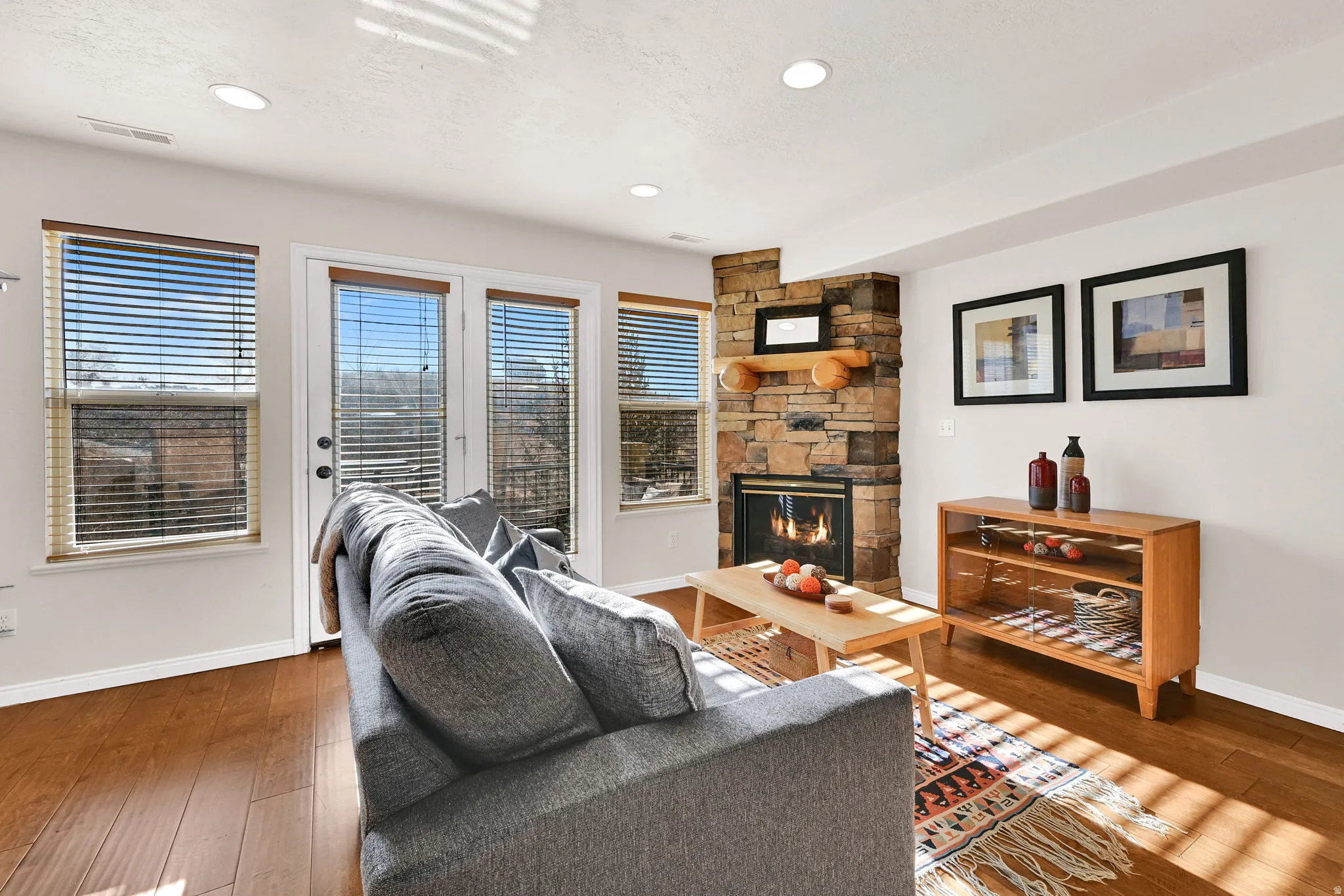 Living area featuring wood-type flooring, a fireplace, and recessed lighting