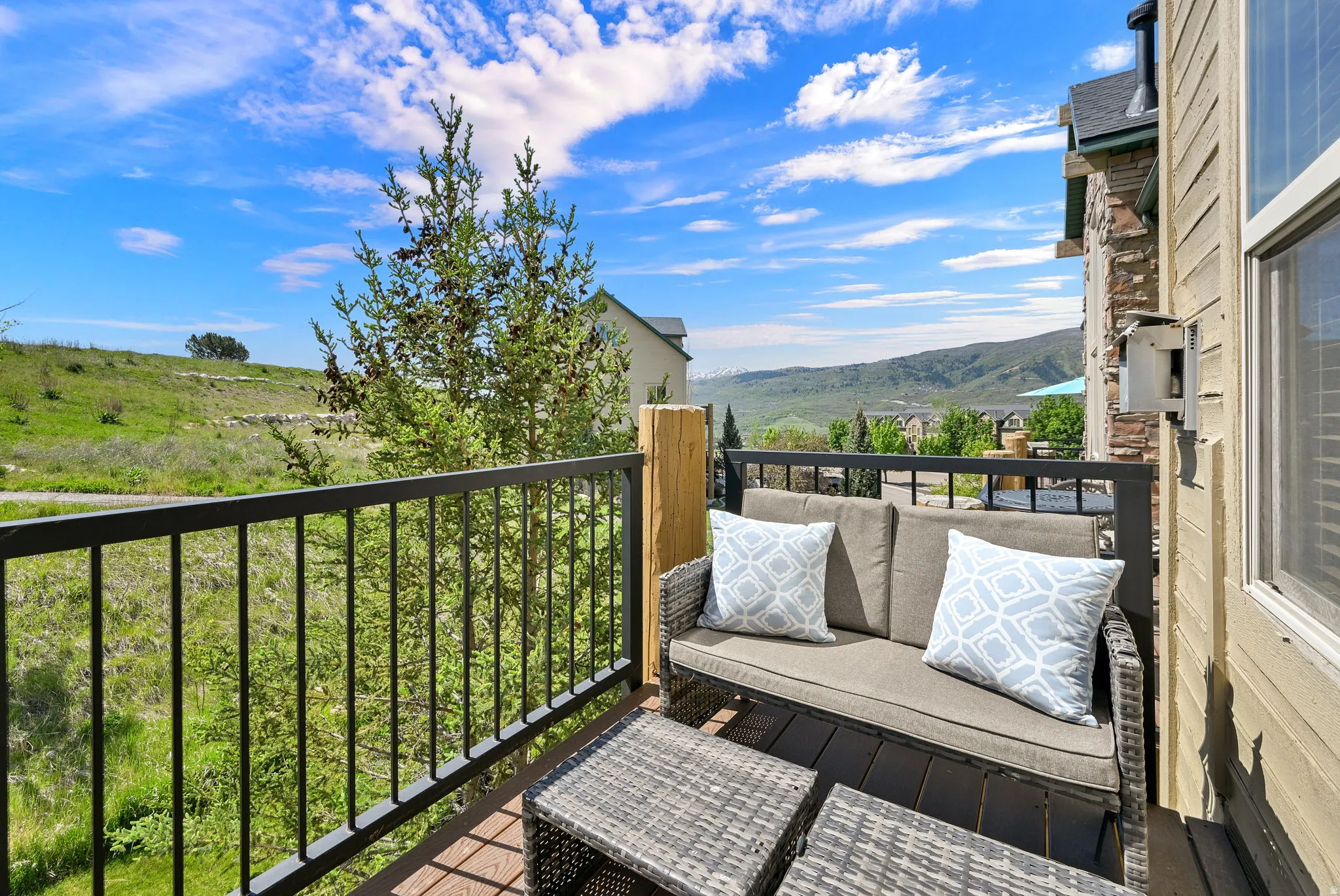 Outdoor balcony with wood-finish decking and black metal railings