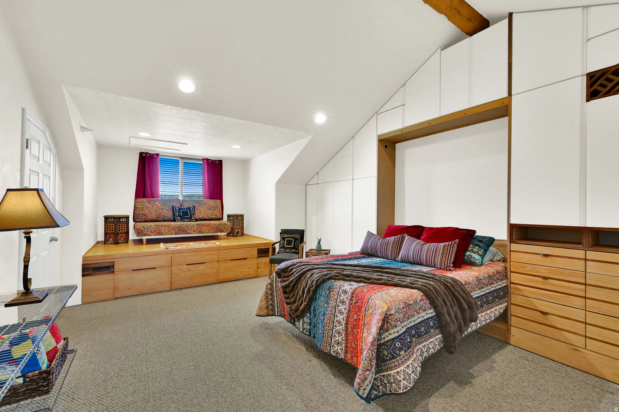 Carpeted room featuring a built-in platform with integrated storage, a window with natural light, and recessed lighting