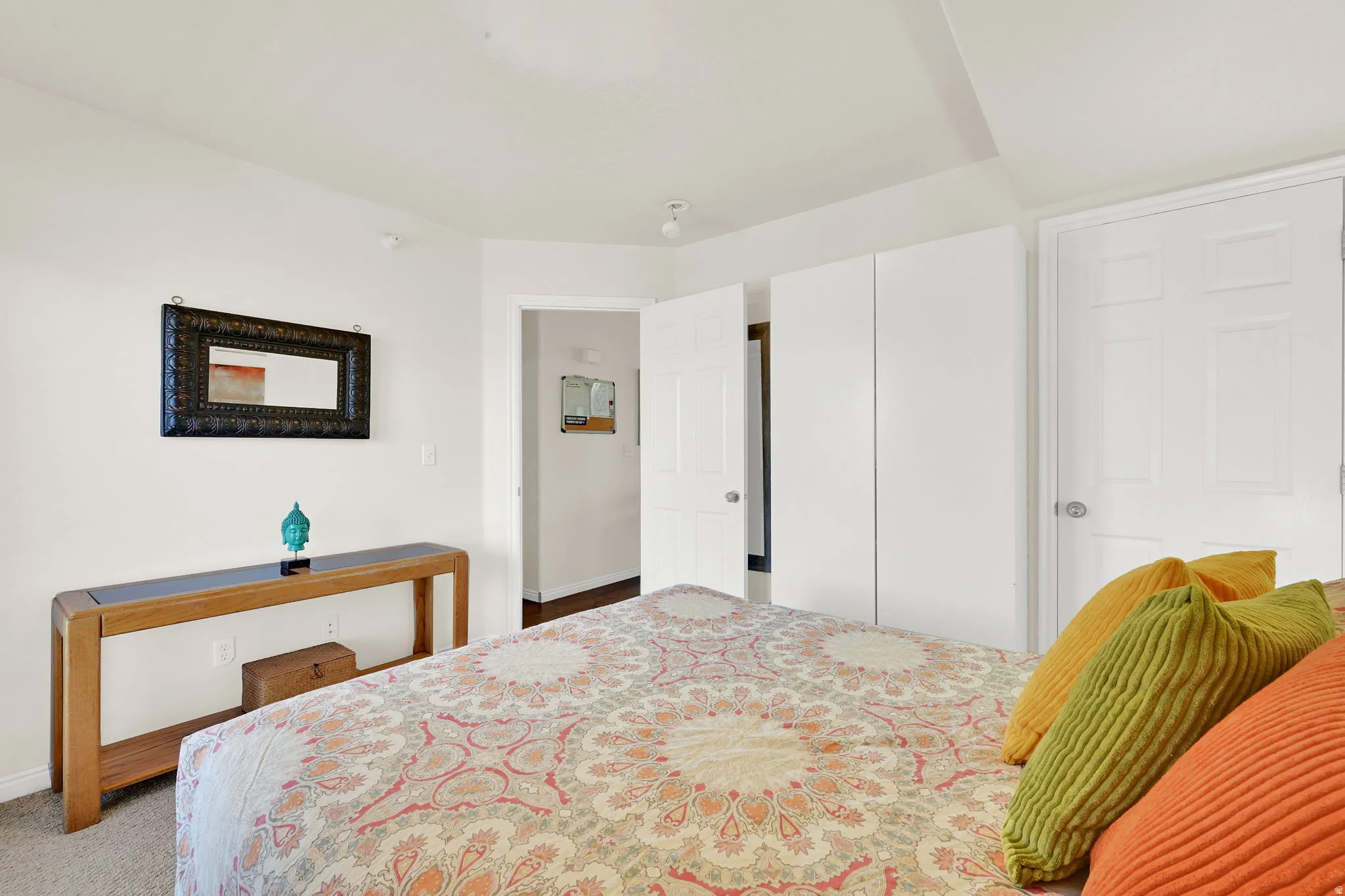 Carpeted bedroom featuring white walls, a built-in wardrobe, and a paneled door