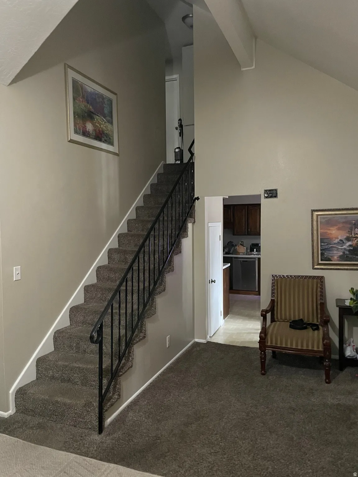 Stairway with carpet floors and a high ceiling