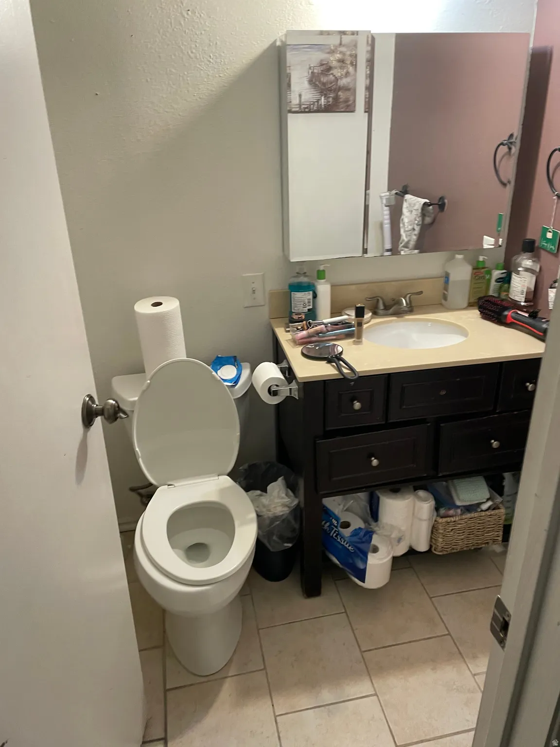 Bathroom featuring vanity, light tile patterned flooring, and a textured wall