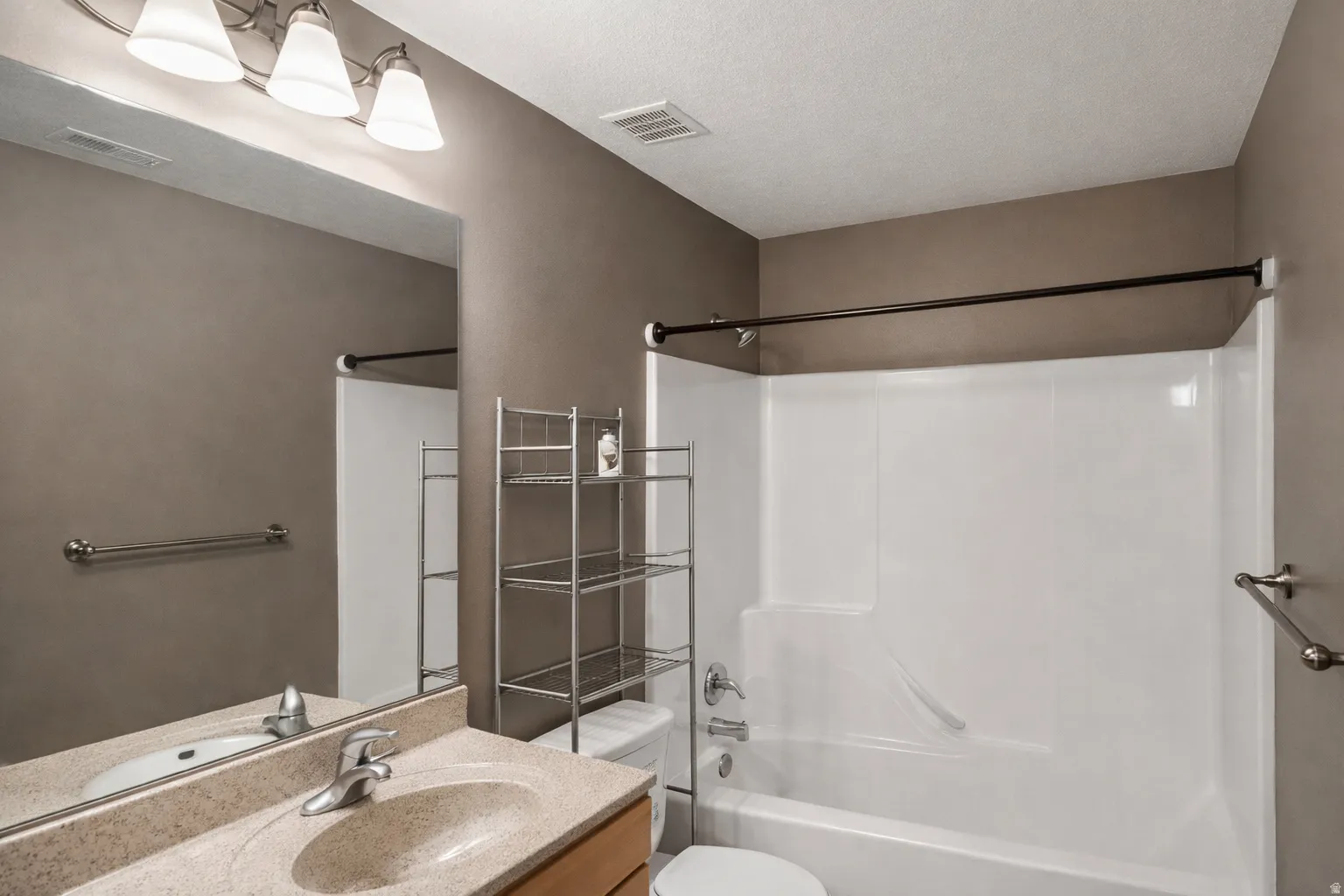 Full bathroom with vanity, bathtub / shower combination, and a textured ceiling