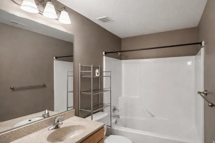 Full bathroom with vanity, bathtub / shower combination, and a textured ceiling