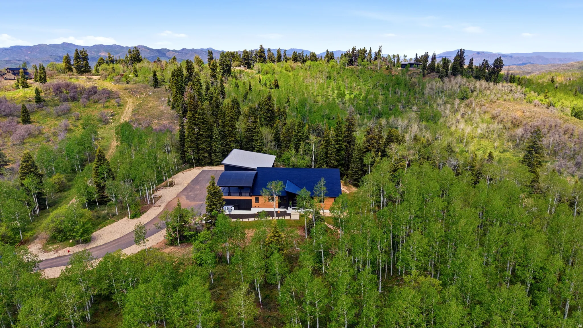 Modern mountain residence nestled among extensive mature trees