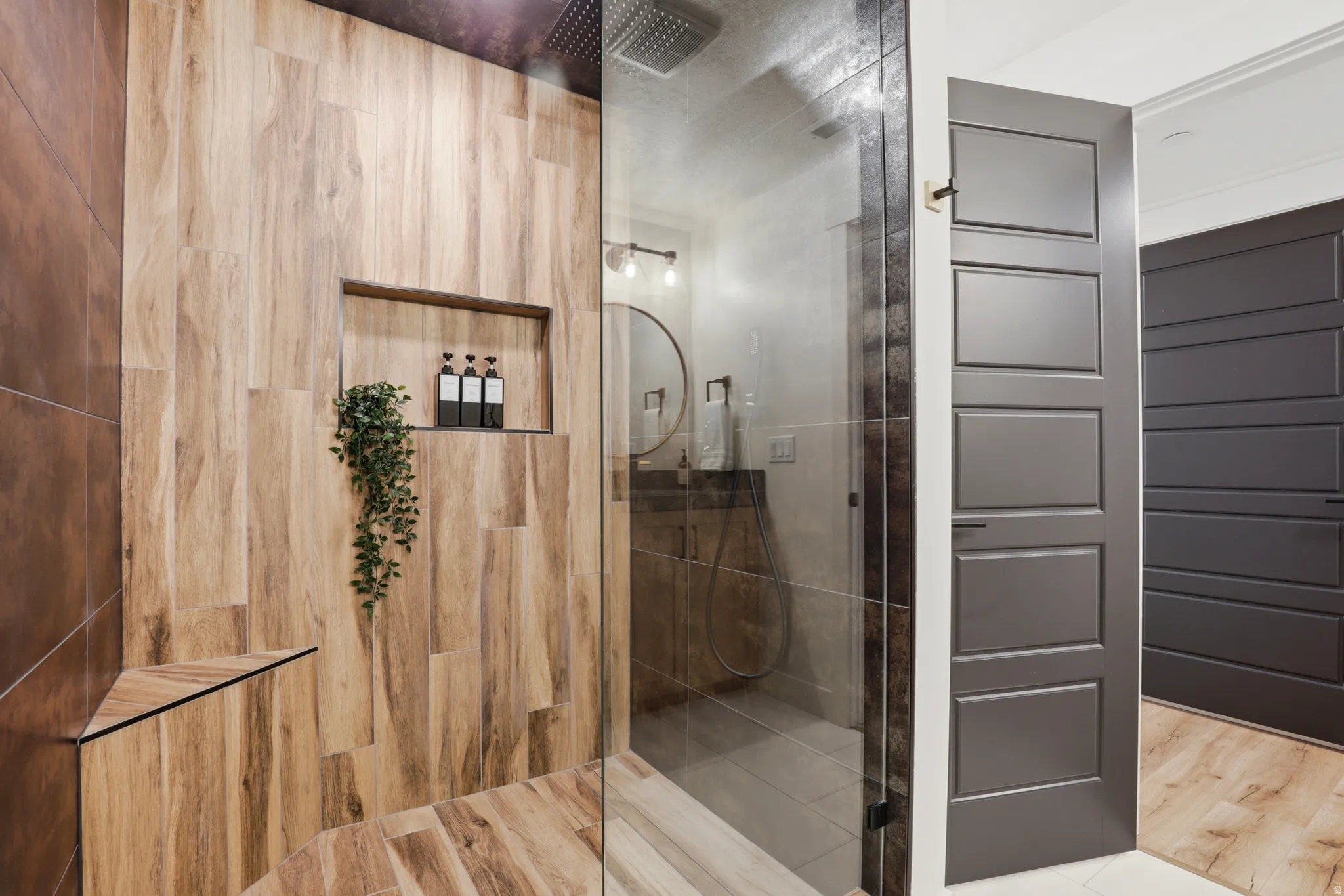 Walk-in shower with wood-look tile surround and an integrated niche