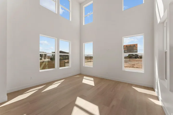 Unfurnished room featuring light wood finished floors and a high ceiling