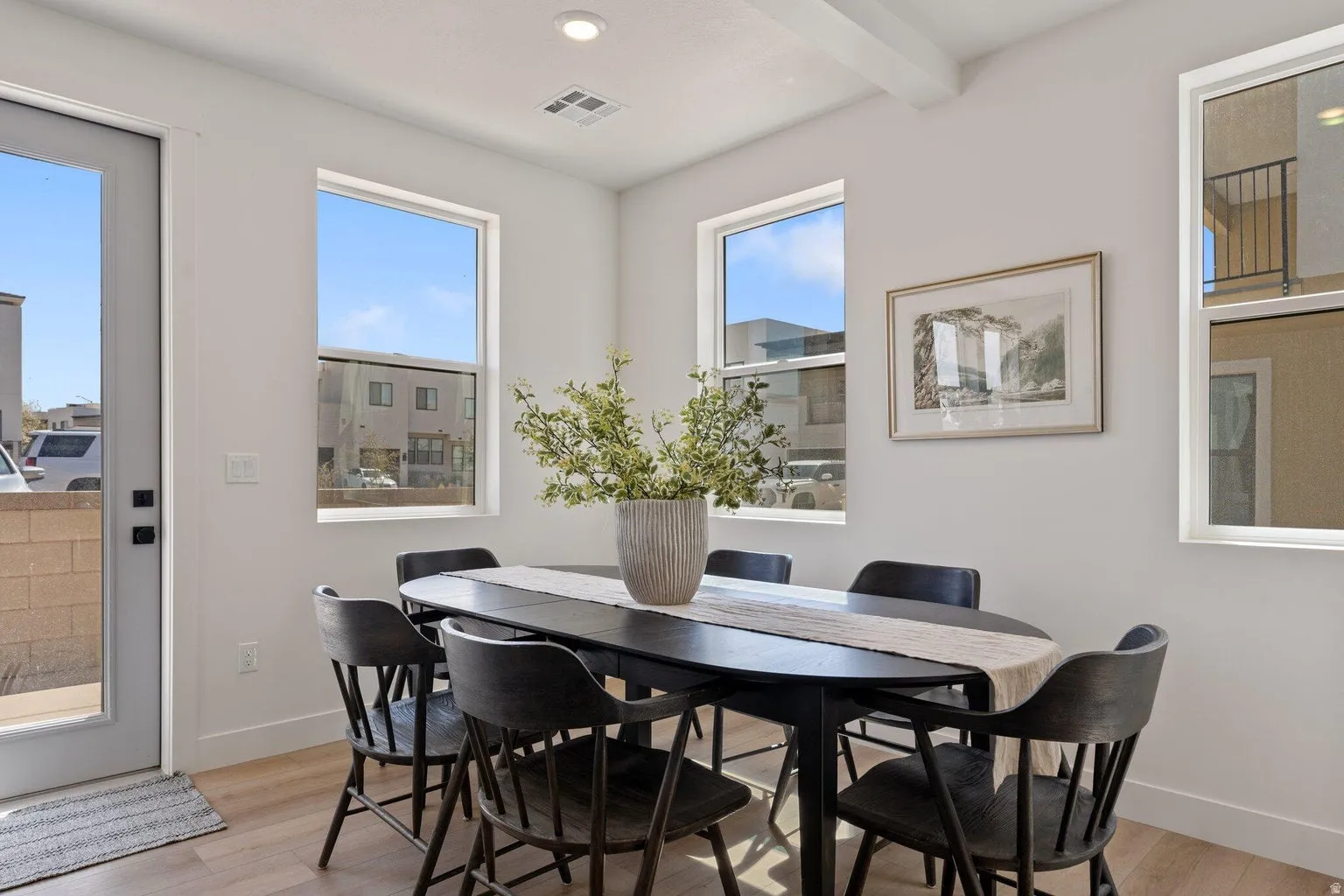Dining space featuring light wood-style floors, recessed lighting, and beamed ceiling