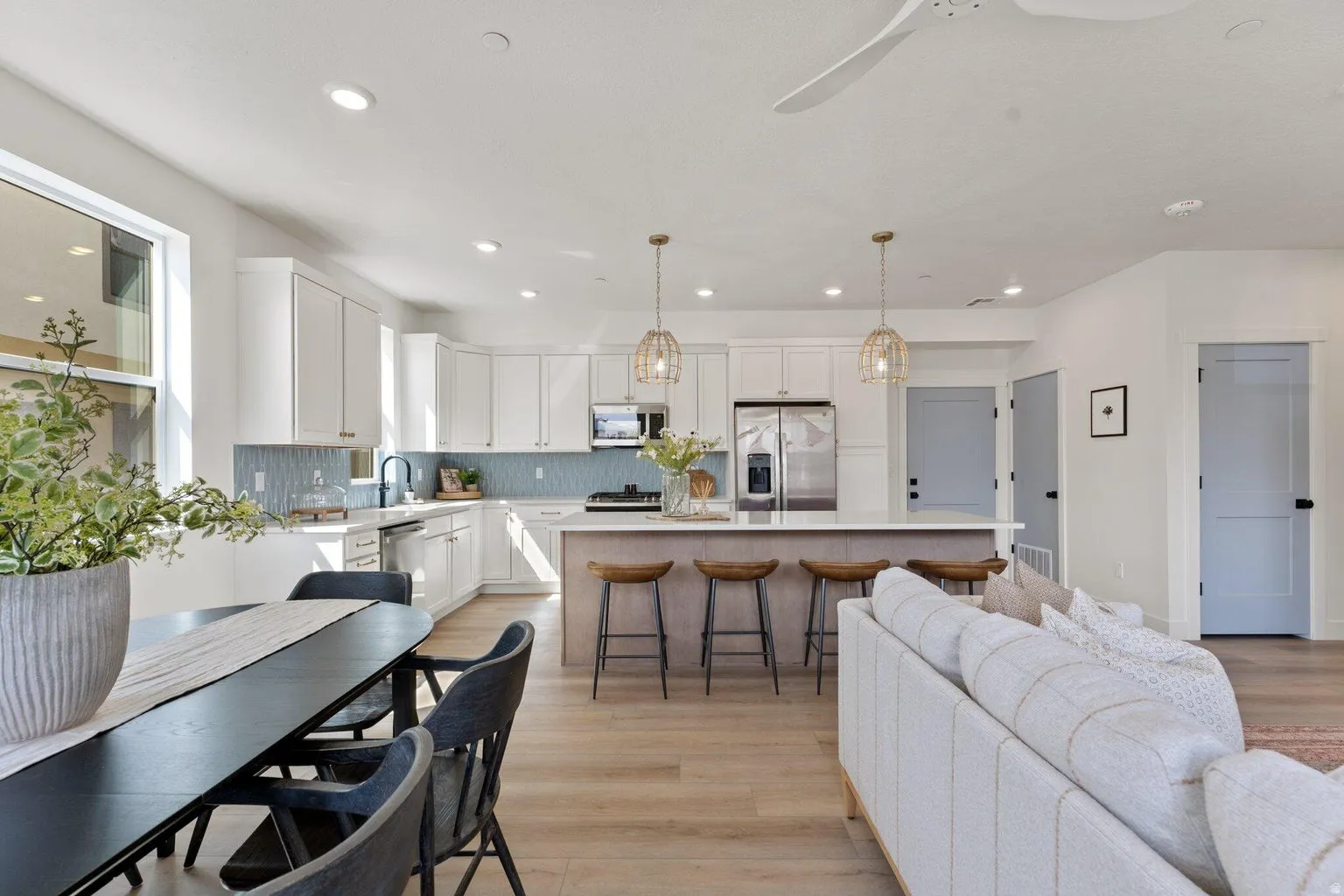 Living area with light wood-style flooring, a ceiling fan, and recessed lighting