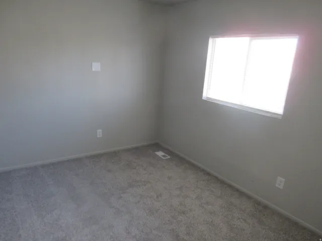 Carpeted empty room featuring baseboards