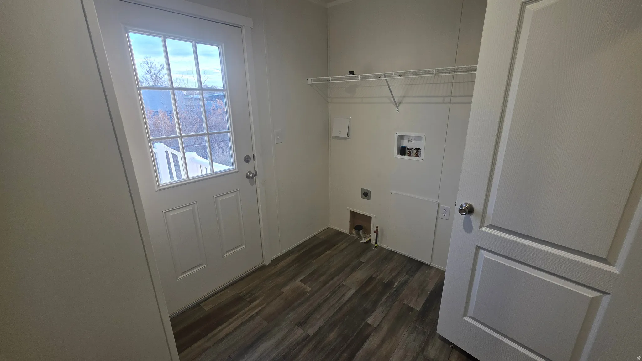 Laundry room with washer hookup, dark wood-type flooring, and hookup for an electric dryer
