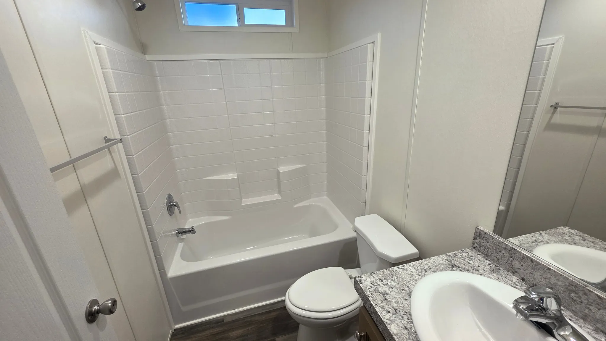 Full bathroom featuring vanity, shower / tub combination, and dark wood-type flooring