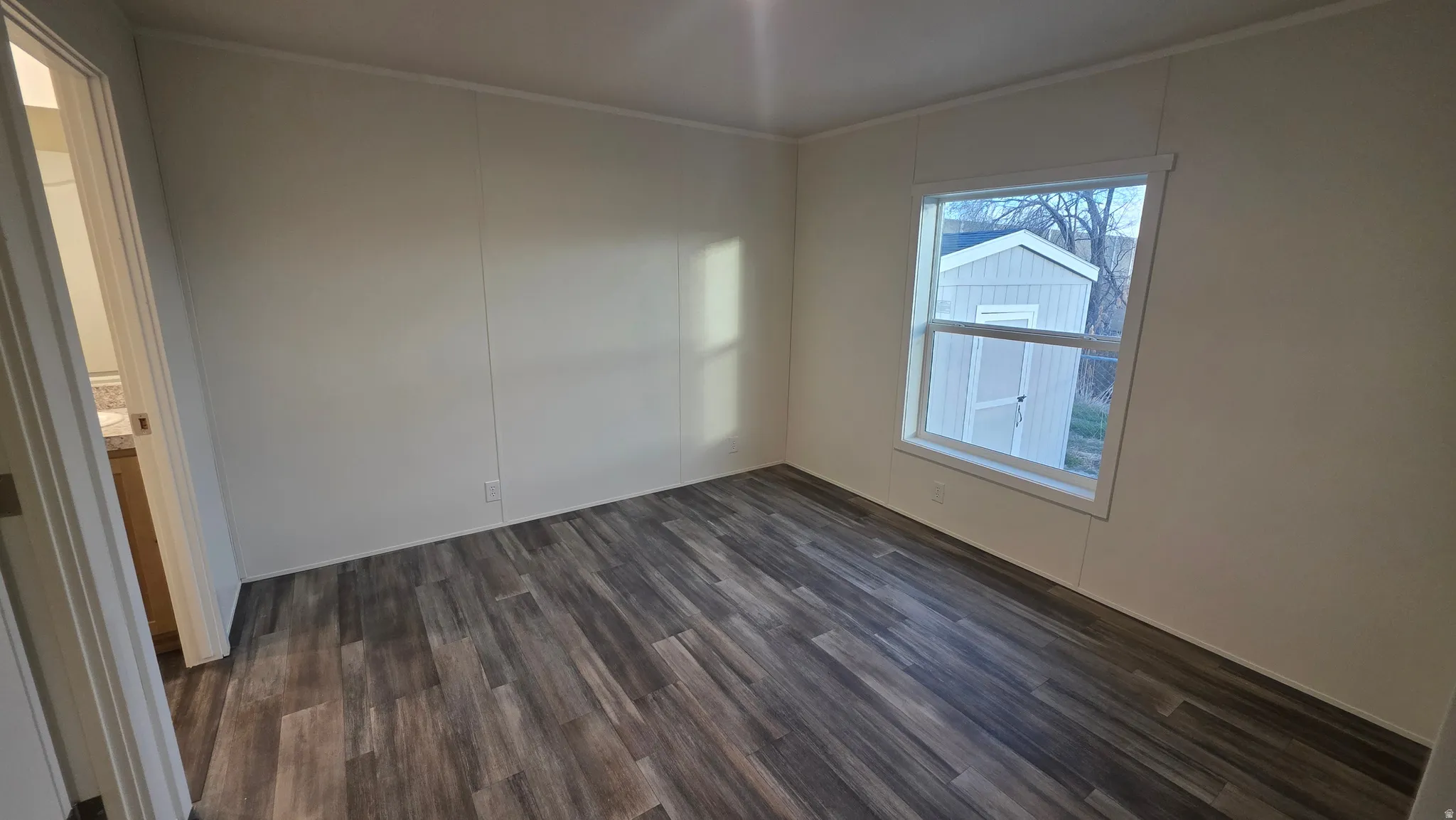 Spare room with dark wood finished floors and ornamental molding