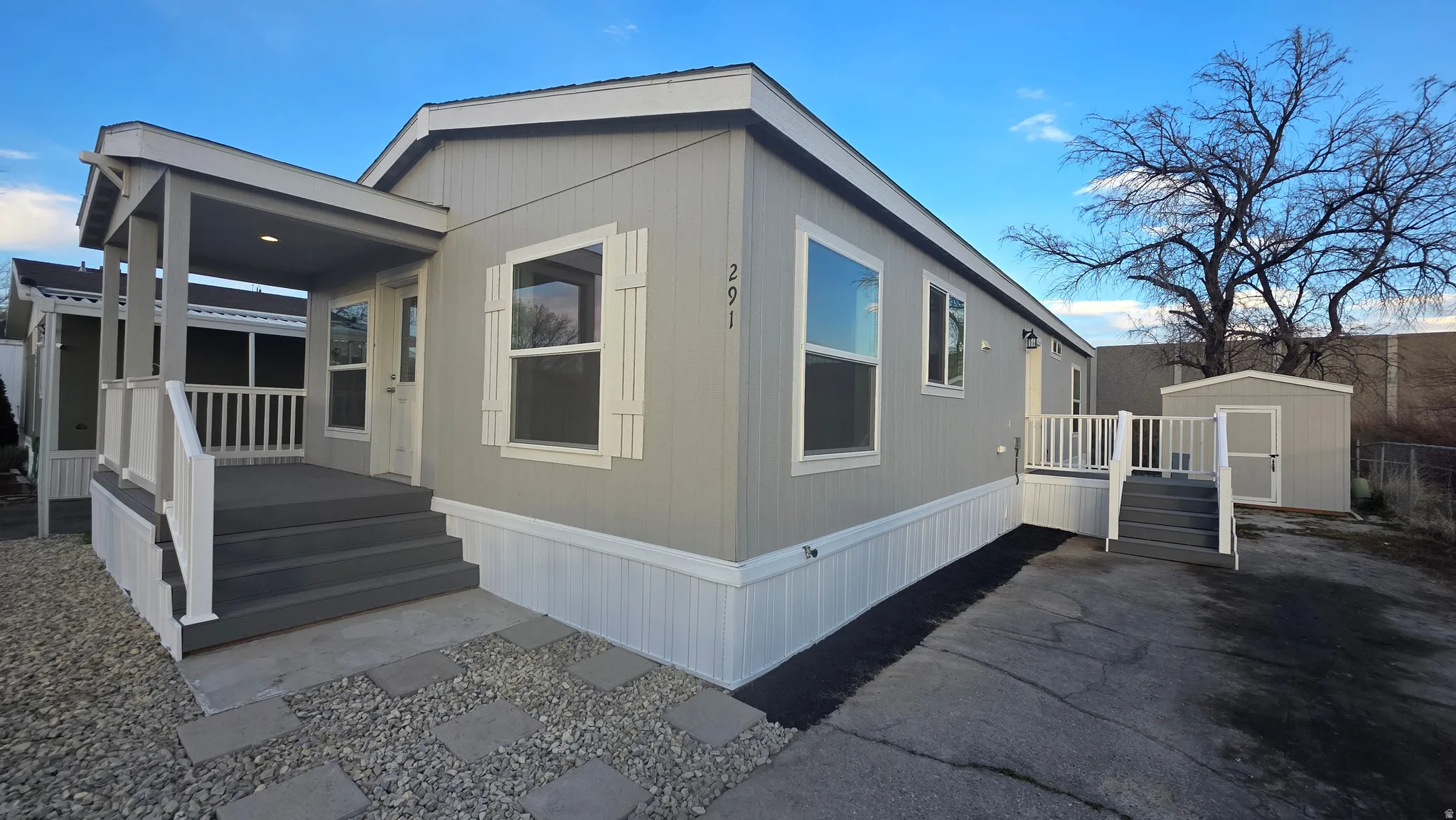 View of property exterior featuring a storage shed and covered porch
