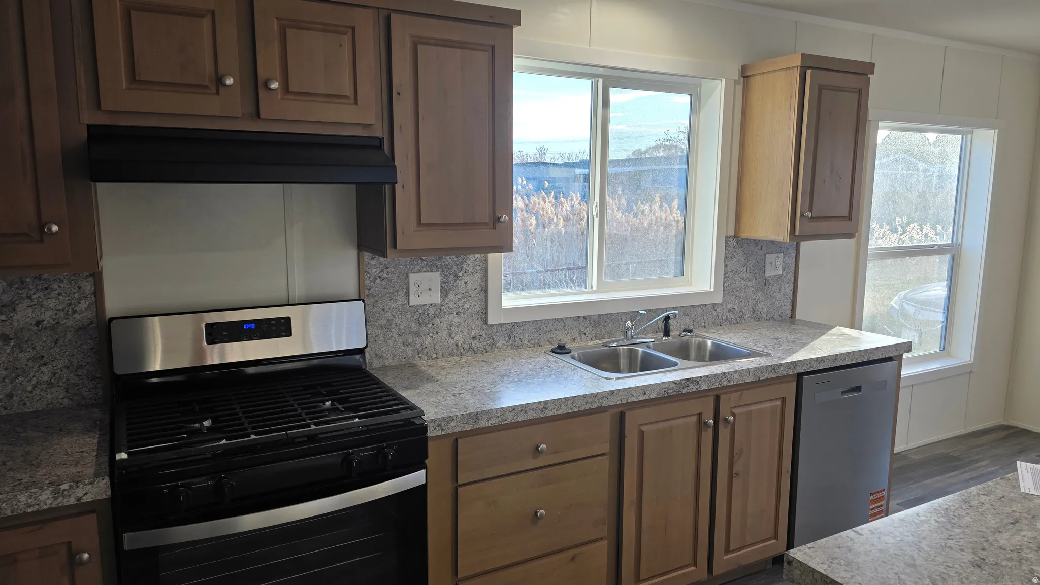 Kitchen featuring stainless steel appliances, dark wood finished floors, and tasteful backsplash