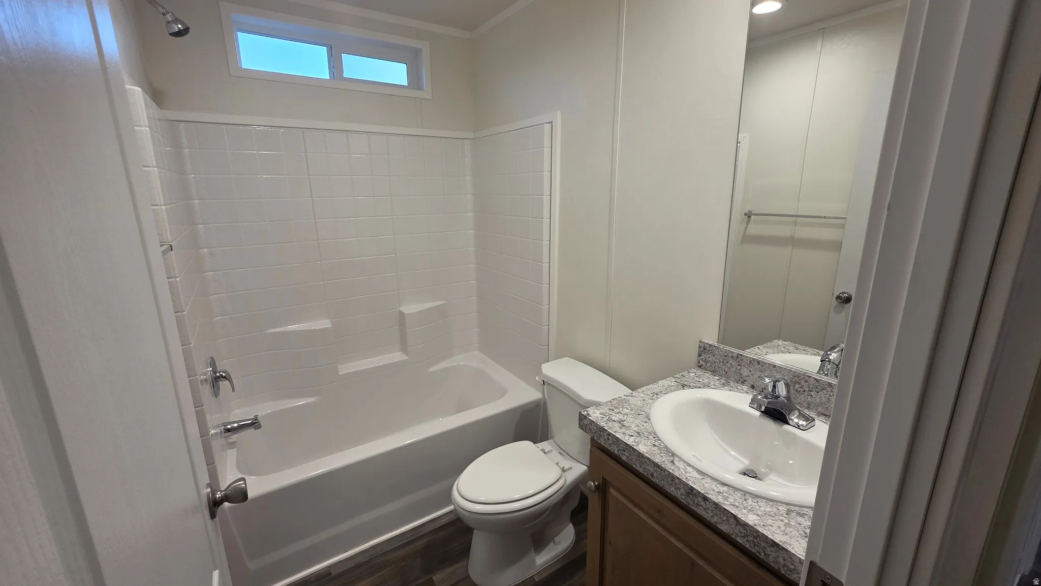 Full bathroom featuring shower / tub combination, vanity, and dark wood-style flooring