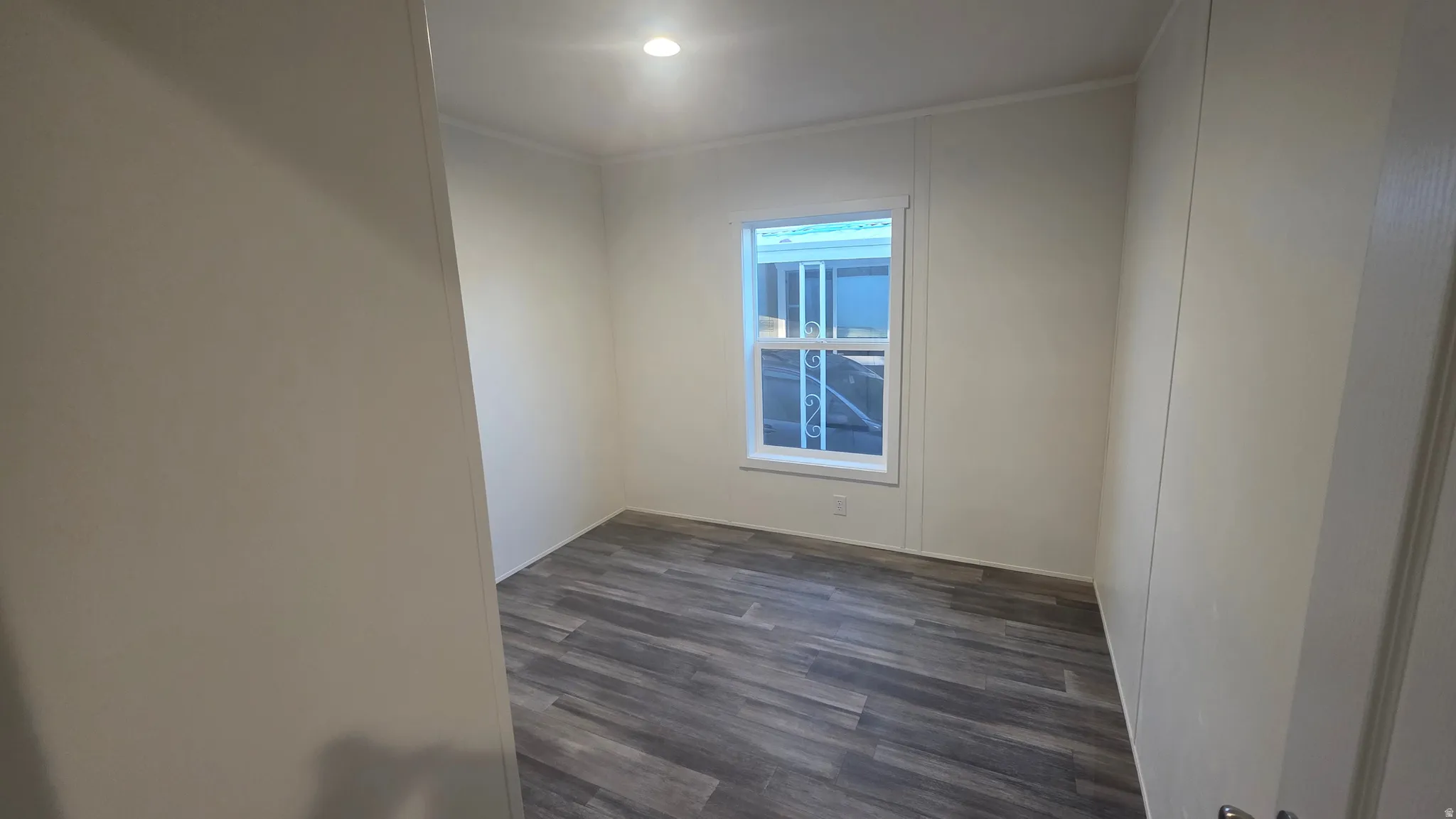 Empty room with dark wood finished floors and ornamental molding