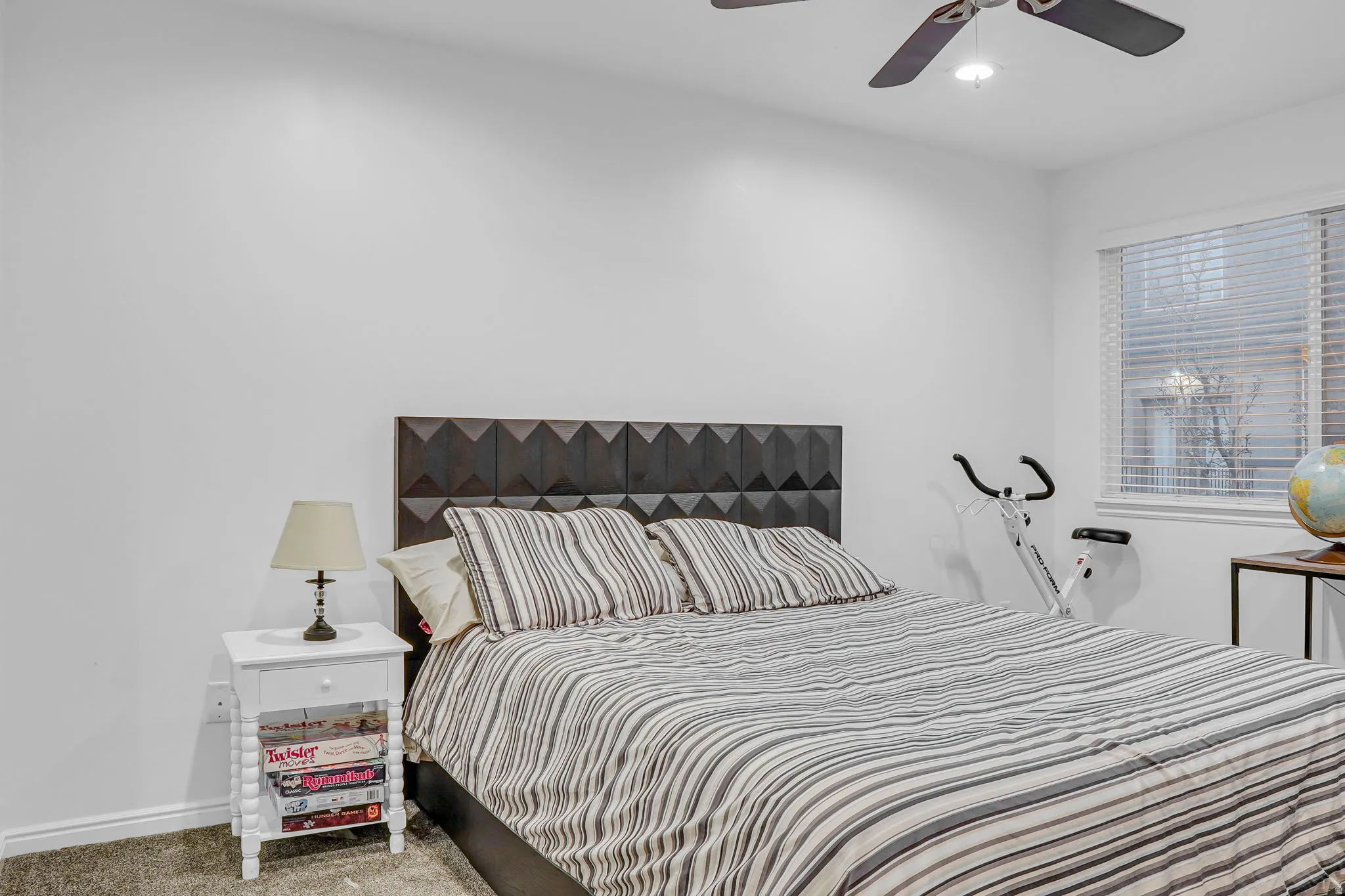 Carpeted bedroom with baseboards and ceiling fan