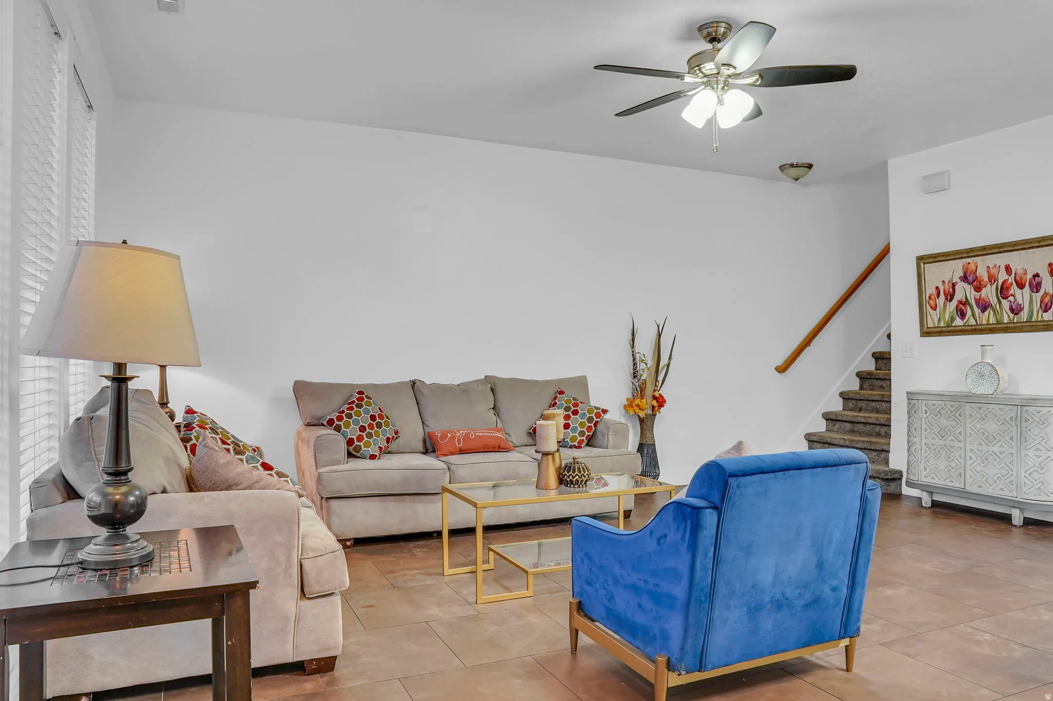 Tiled living room featuring stairway and ceiling fan