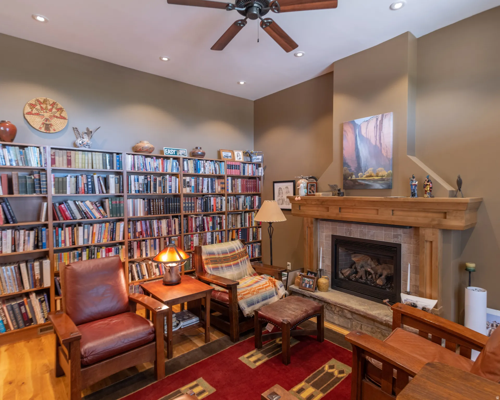 Living area featuring a tile fireplace, ceiling fan, recessed lighting, and wood finished floors