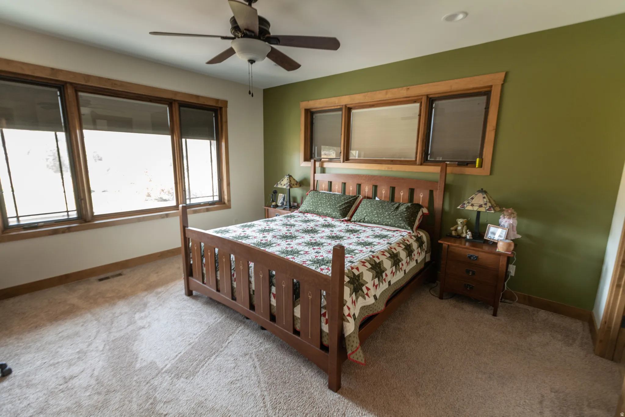 Carpeted bedroom featuring ceiling fan and baseboards