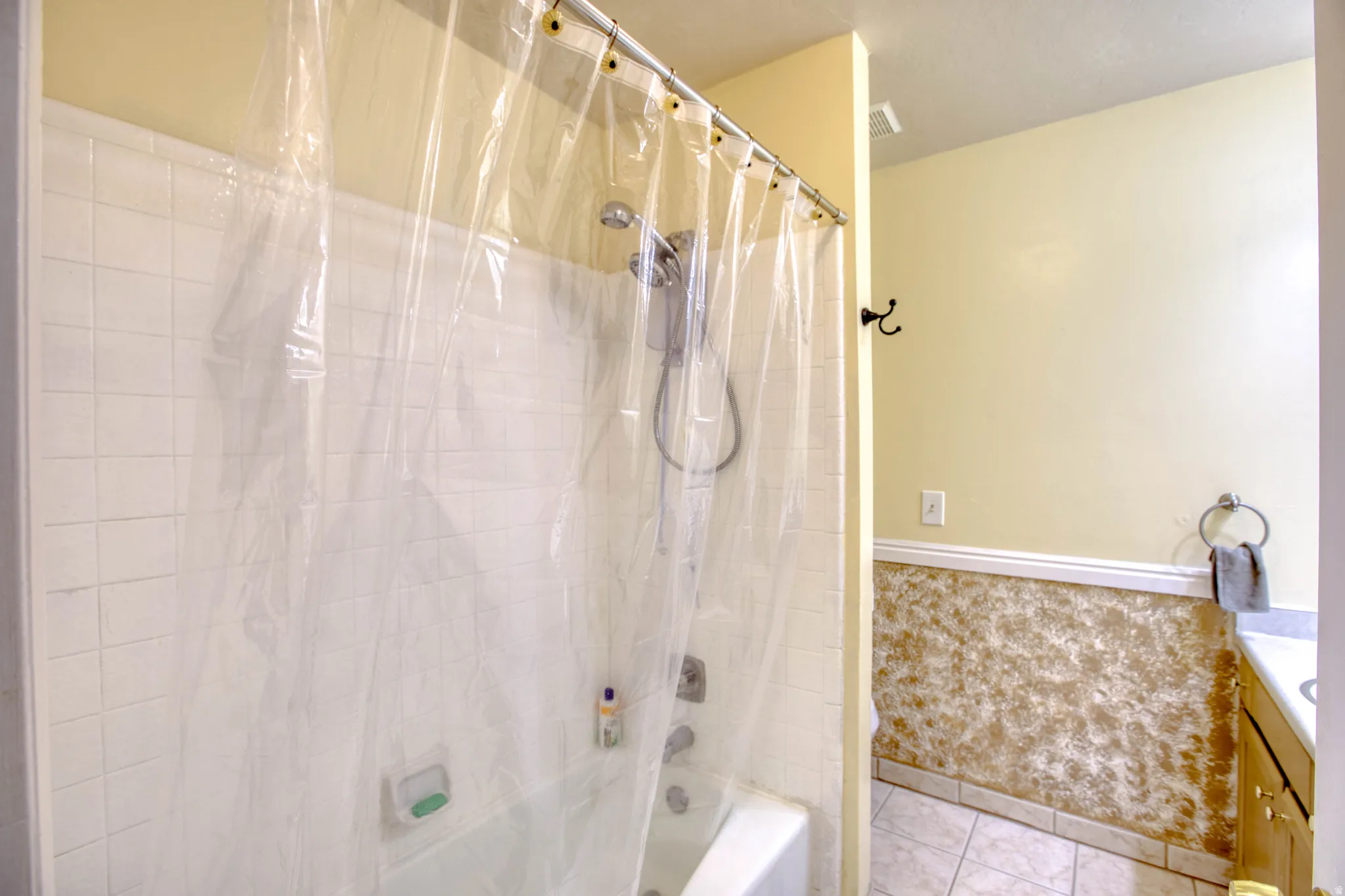 Full bathroom featuring vanity, shower / tub combo, and light tile patterned floors