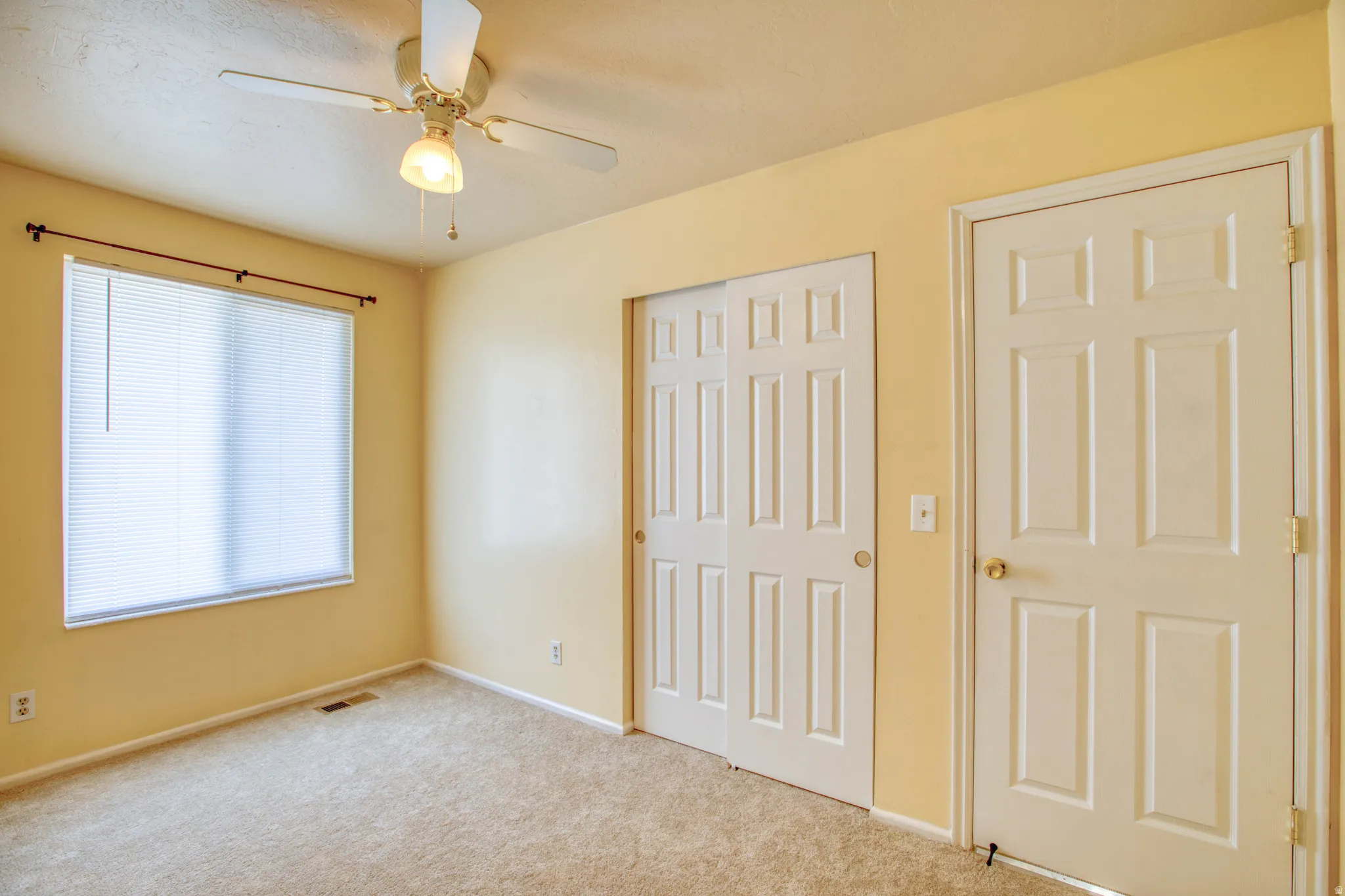 Unfurnished bedroom with carpet, a closet, and a ceiling fan