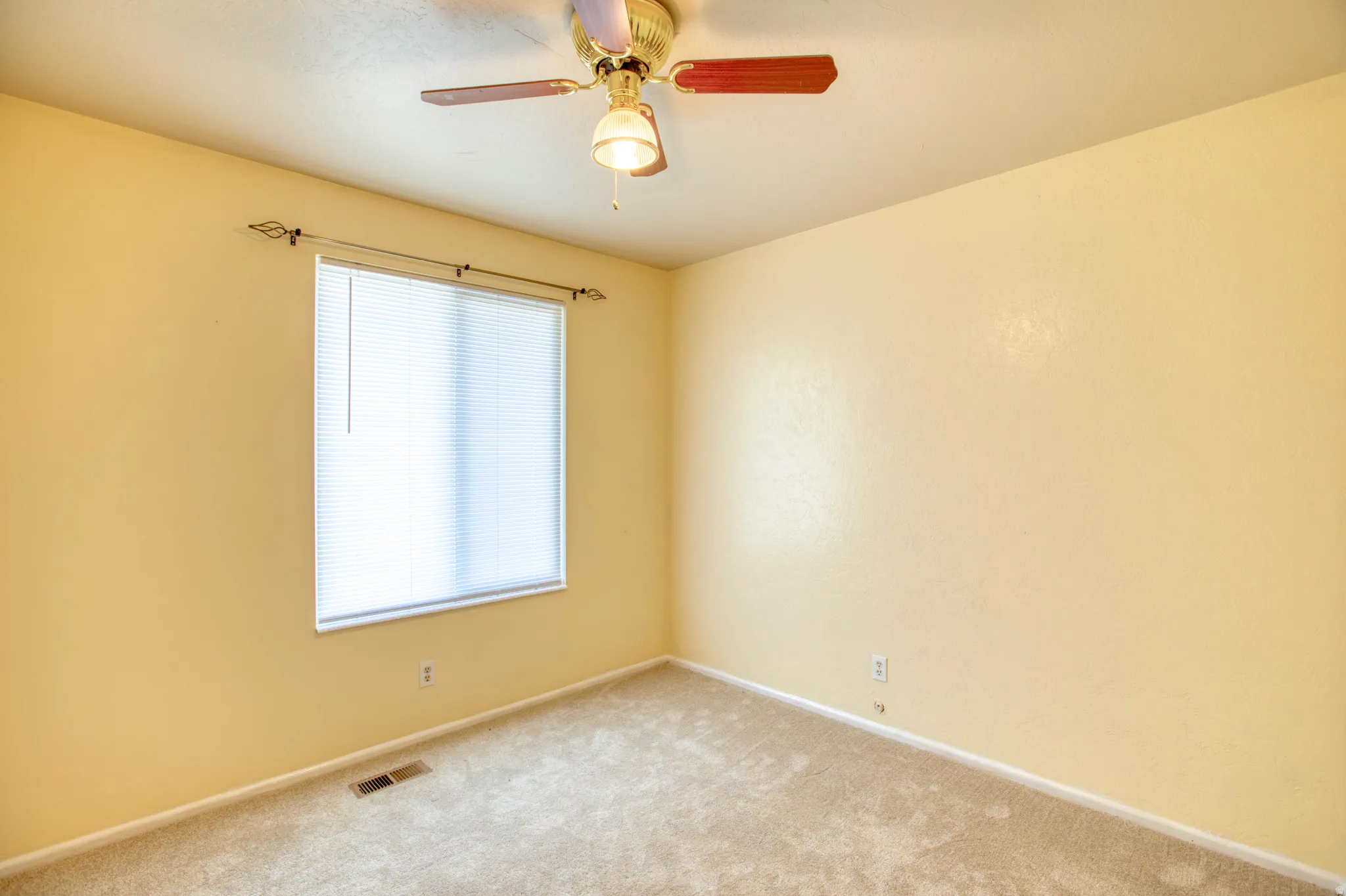 Spare room with carpet floors and ceiling fan