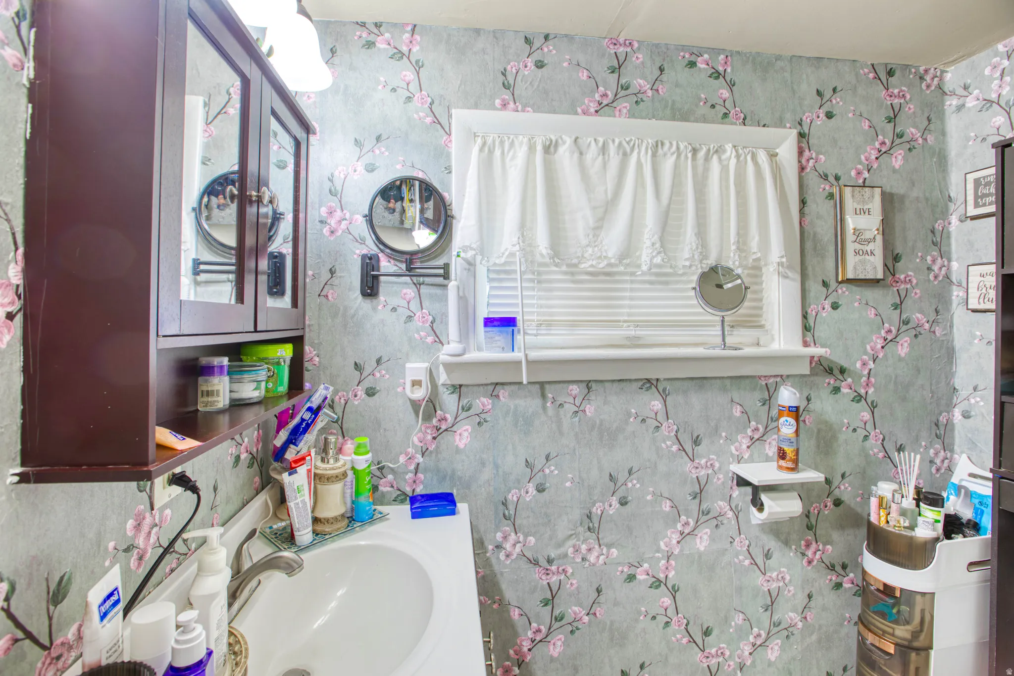 Bathroom with vanity and wallpapered walls