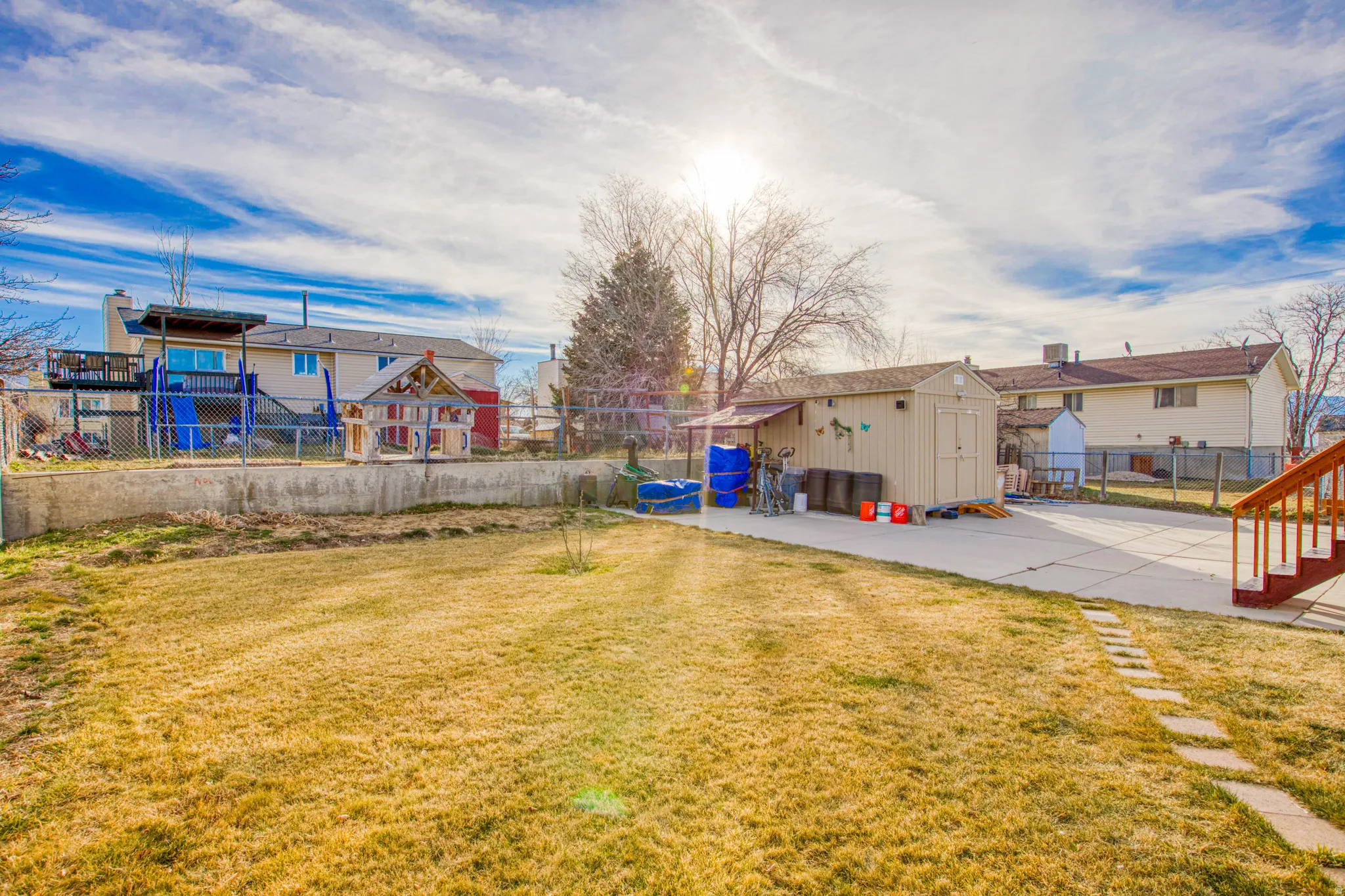 Fenced backyard featuring a storage shed and a patio
