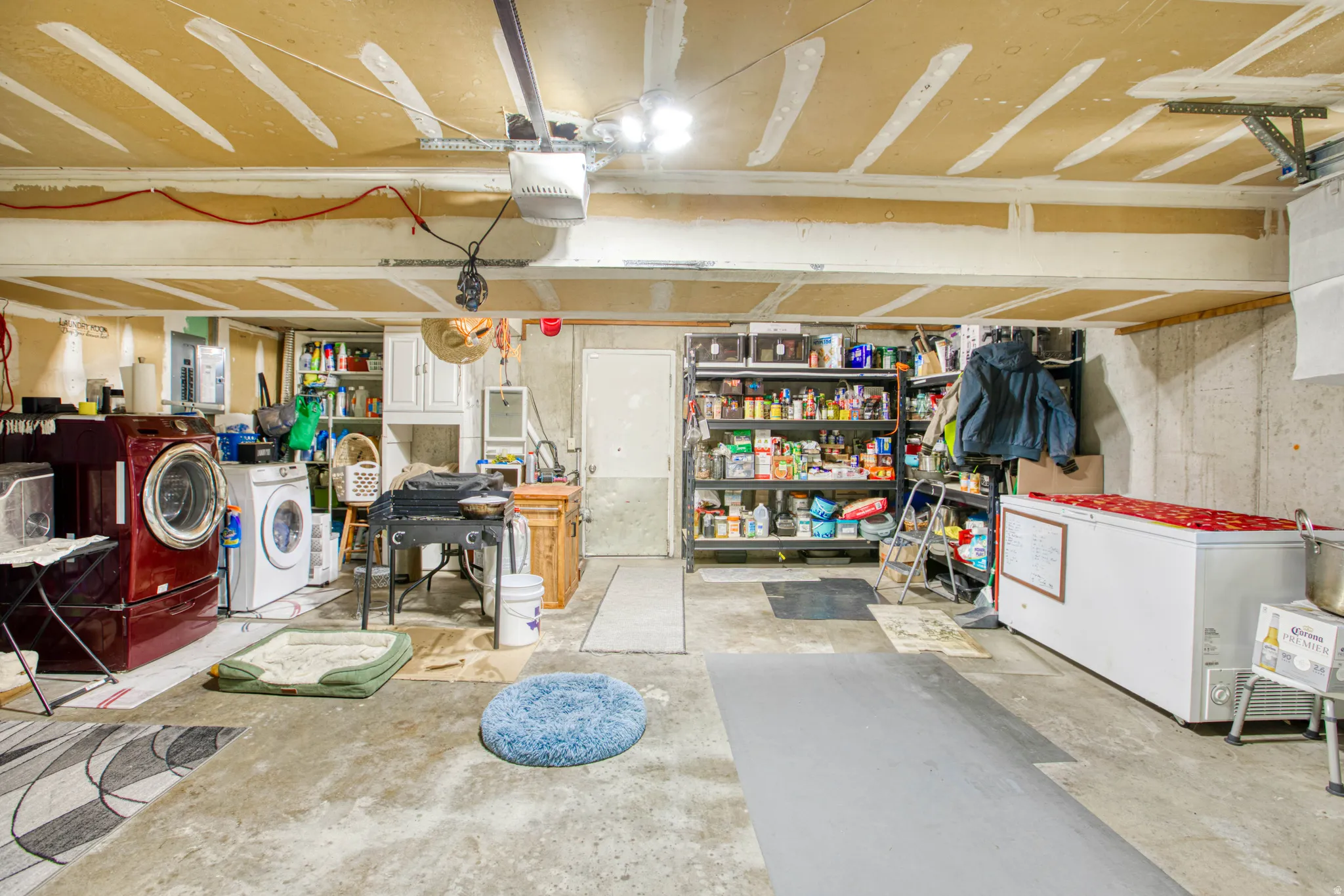 Garage with washing machine and dryer, a garage door opener, and white fridge