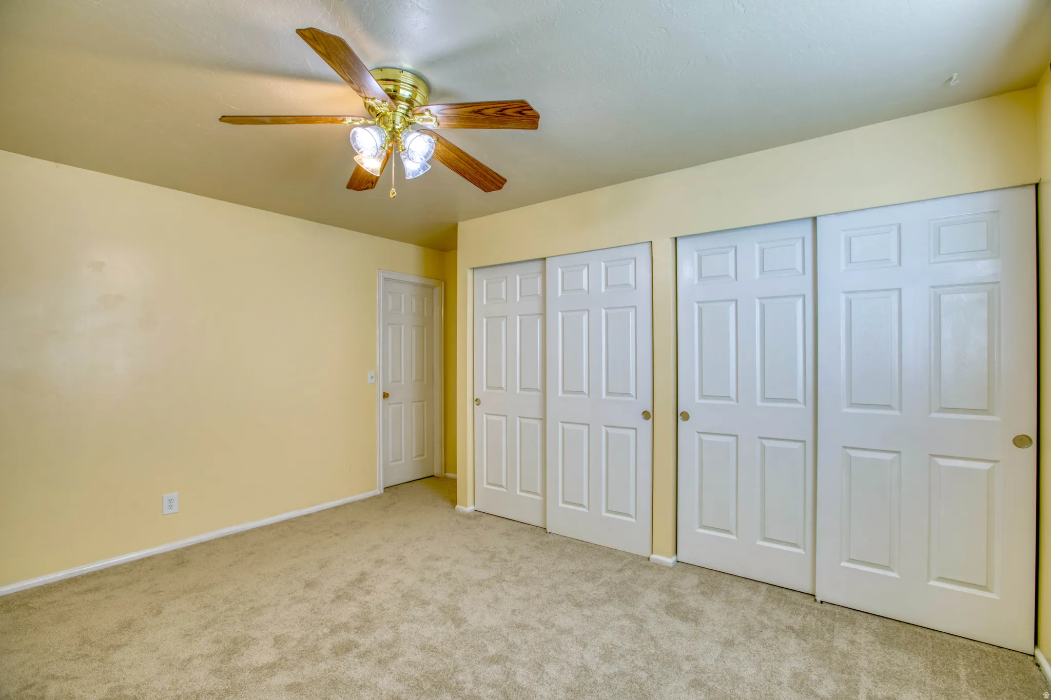 Unfurnished bedroom featuring two closets, carpet flooring, and a ceiling fan