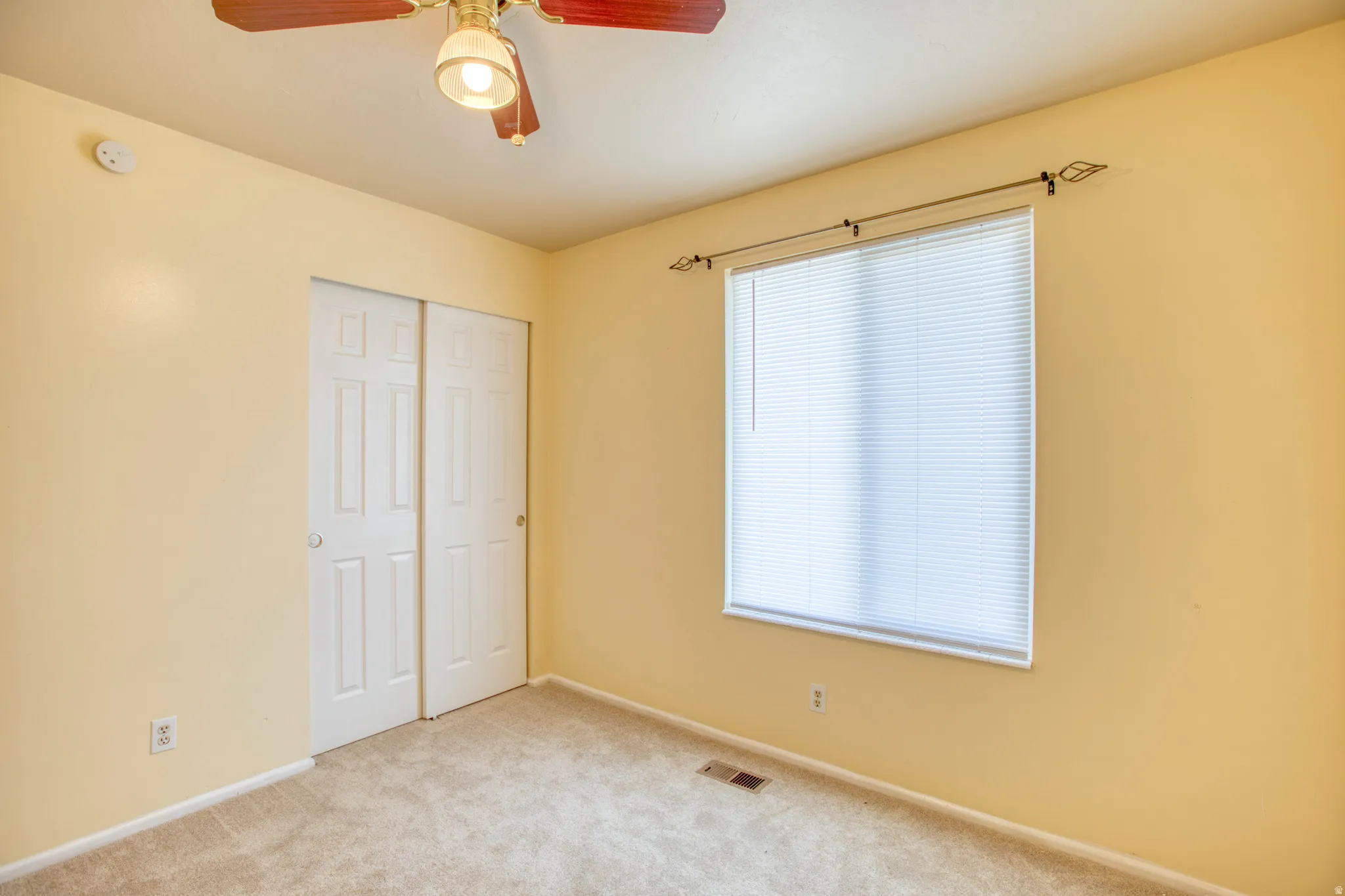 Unfurnished bedroom with carpet floors, a ceiling fan, and a closet