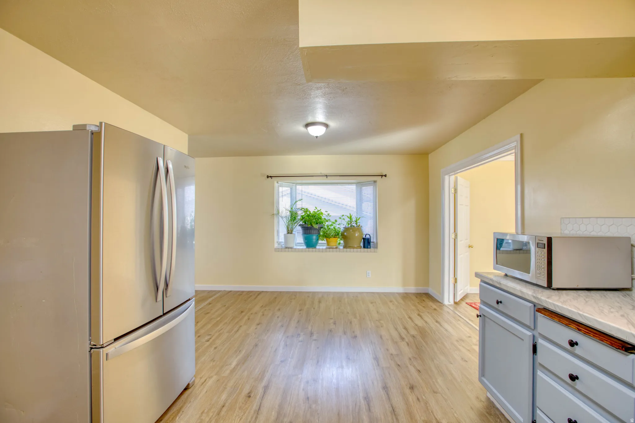 Kitchen featuring stainless steel appliances, light wood finished floors, and gray cabinetry