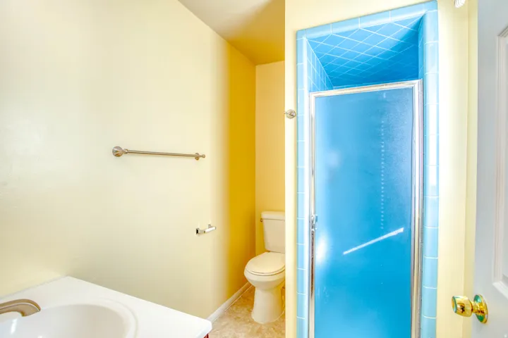Bathroom with vanity, a stall shower, and tile patterned flooring
