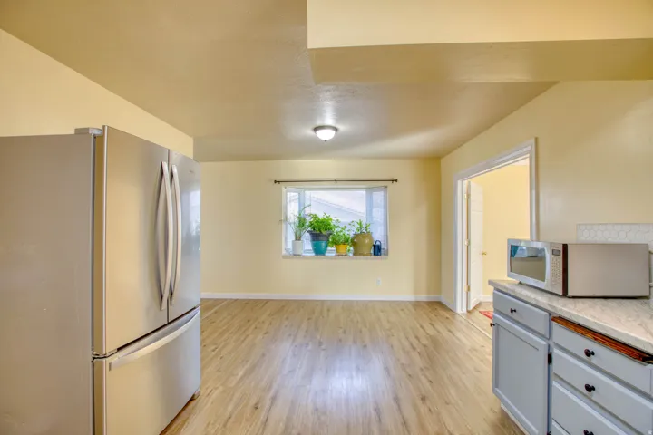 Kitchen featuring stainless steel appliances, light wood finished floors, and gray cabinetry