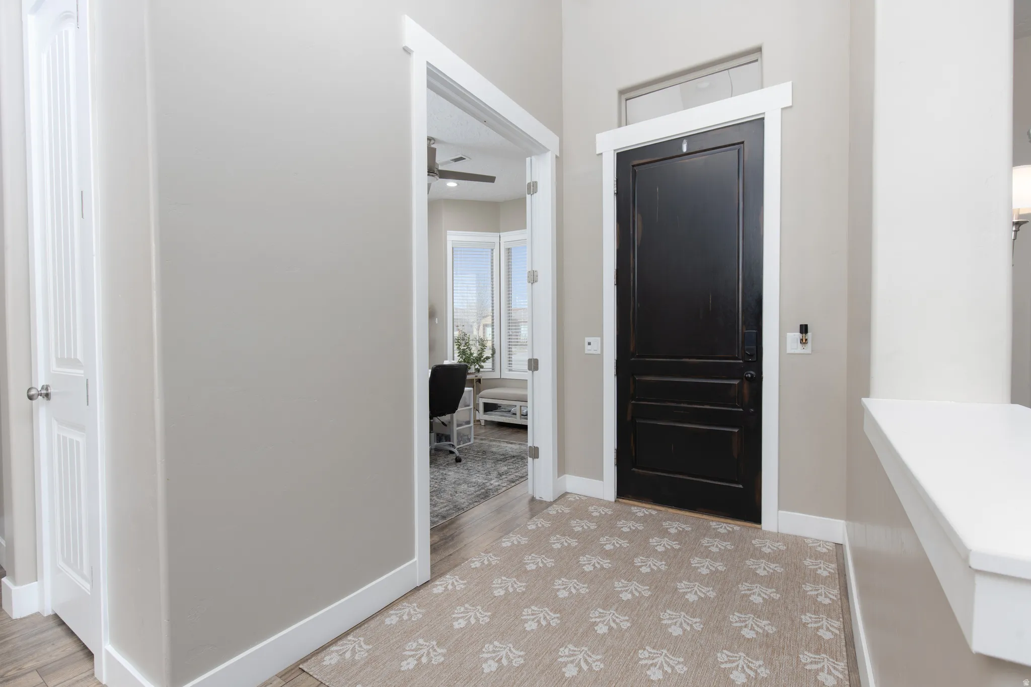 Foyer entrance featuring a ceiling fan and light wood-style flooring