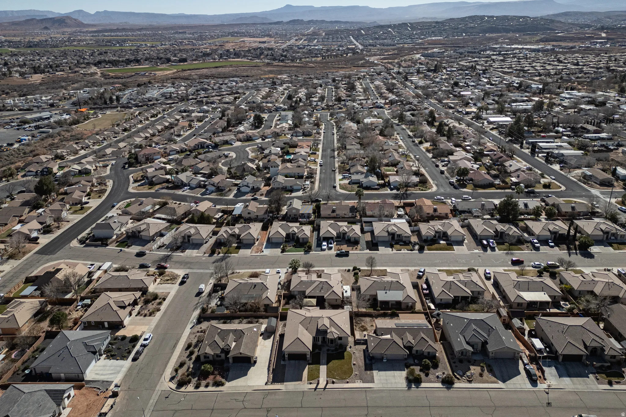 Aerial overview of property's location with a mountain backdrop and nearby suburban area