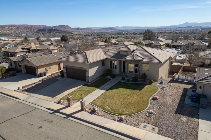 View of front of home with a residential view, concrete driveway, an attached garage, stucco siding, and a mountain view